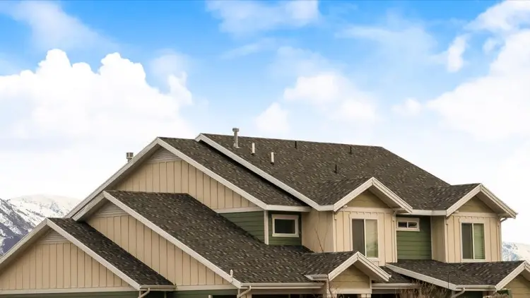 Cream and green sided house with gable roof