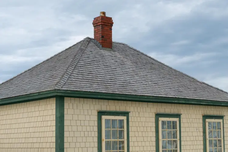 Cream colored house with green trim and hip roof