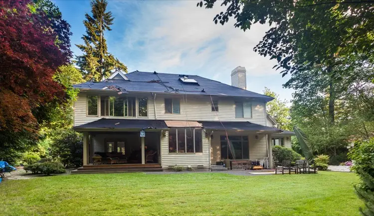View of house from backyard undergoing roof replacement