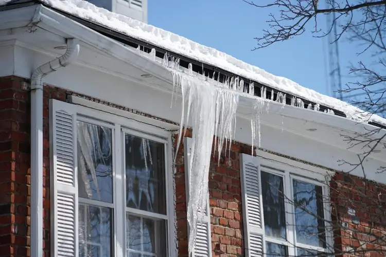 Brick house with ice and snow damaging gutter system