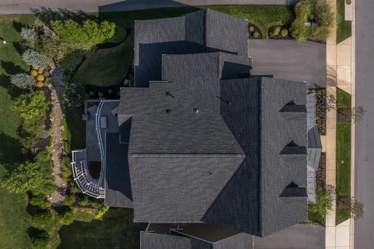 Aerial view of gray shingle roof on a large home showing ridge line and flashing details