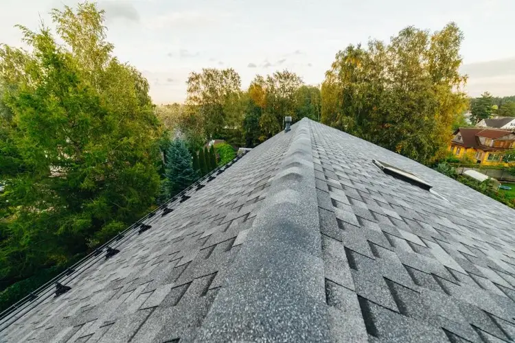 Overhead view of a deteriorating ridge cap on a shingle roof