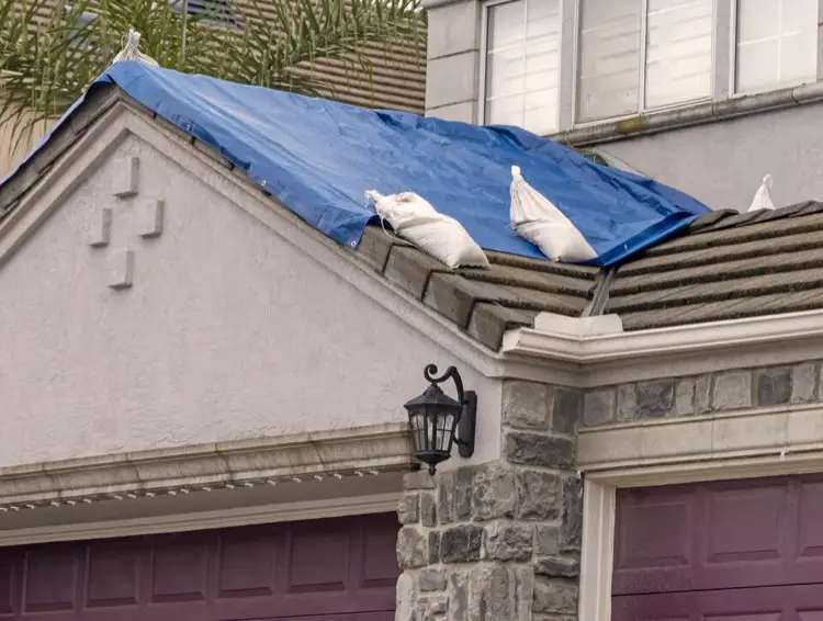 Blue tarp on roof after storm damage