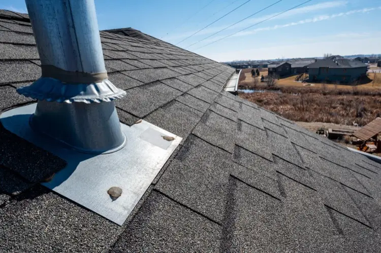 Rubber pipe boot flashing around a vent pipe on a shingle roof
