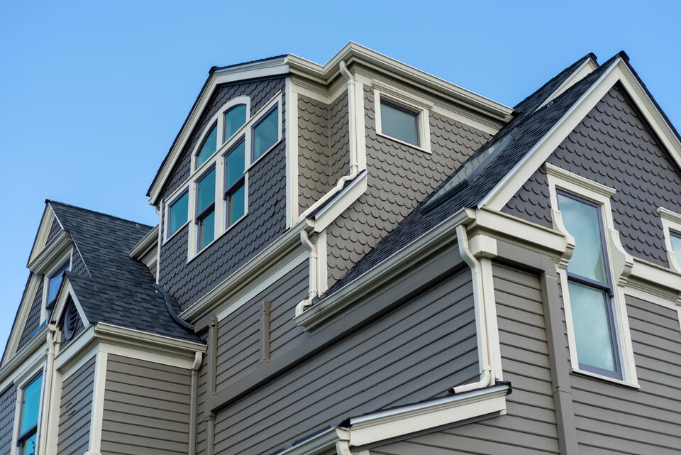 gray textured siding on house with white trim and dark gray shingle roof