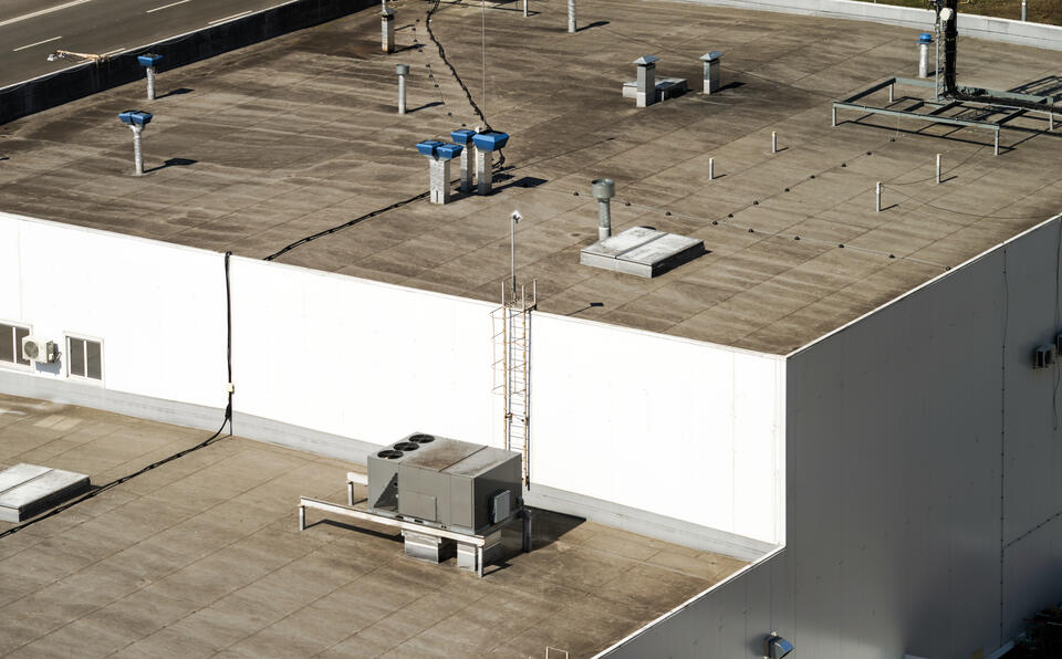 aerial view of multilevel commercial roof with hvac appliances on surface