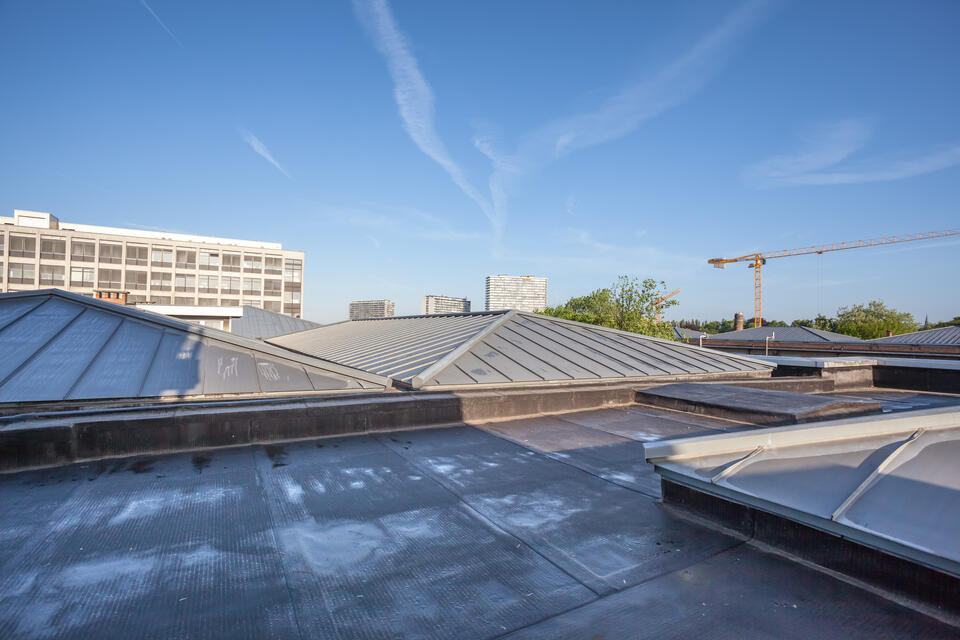 dark commercial roof with some elevated peaks covered in metal commercial roofing materials