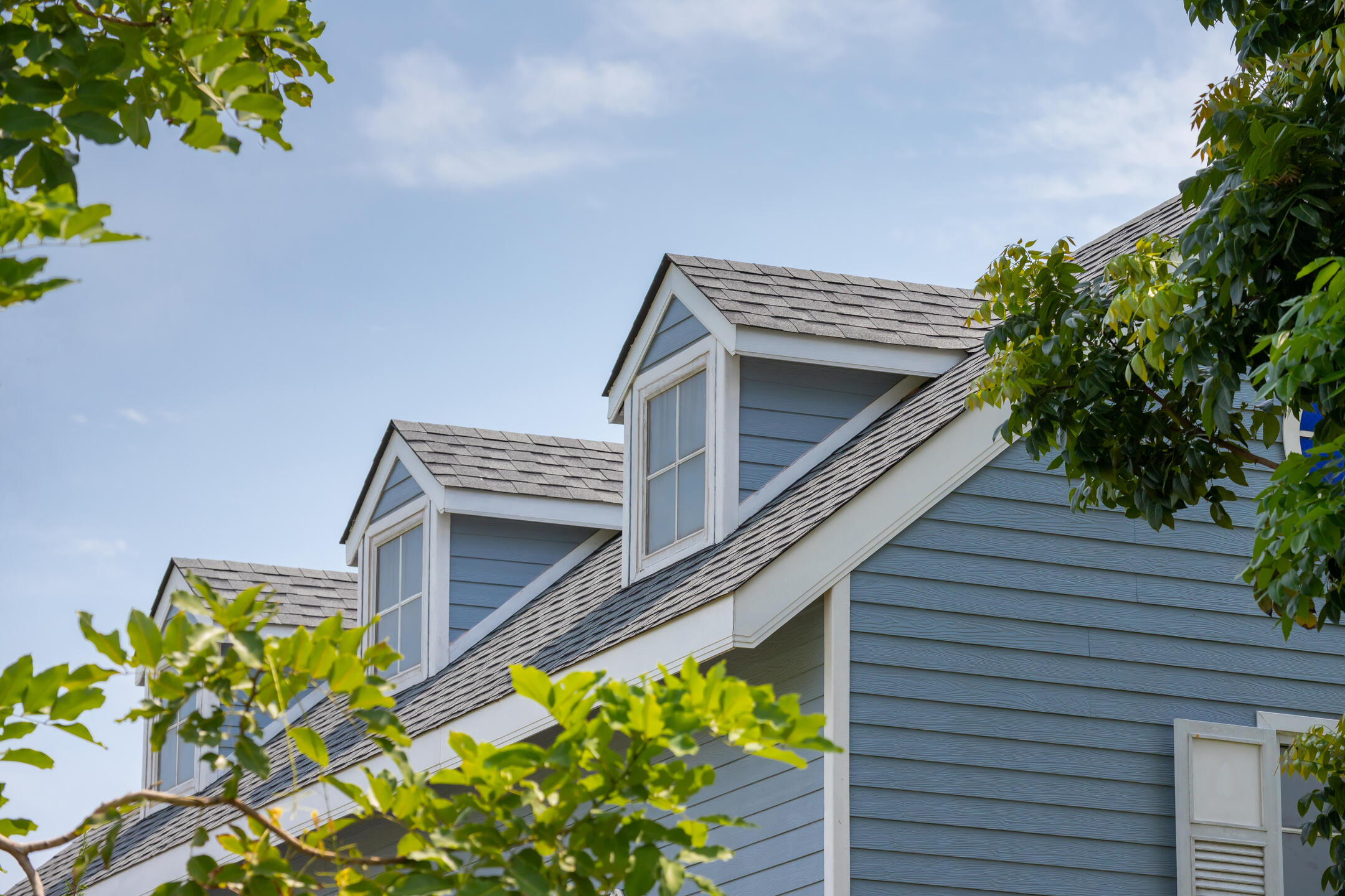 architectural shingles vs 3 tab-blue sided house with light gray shingles
