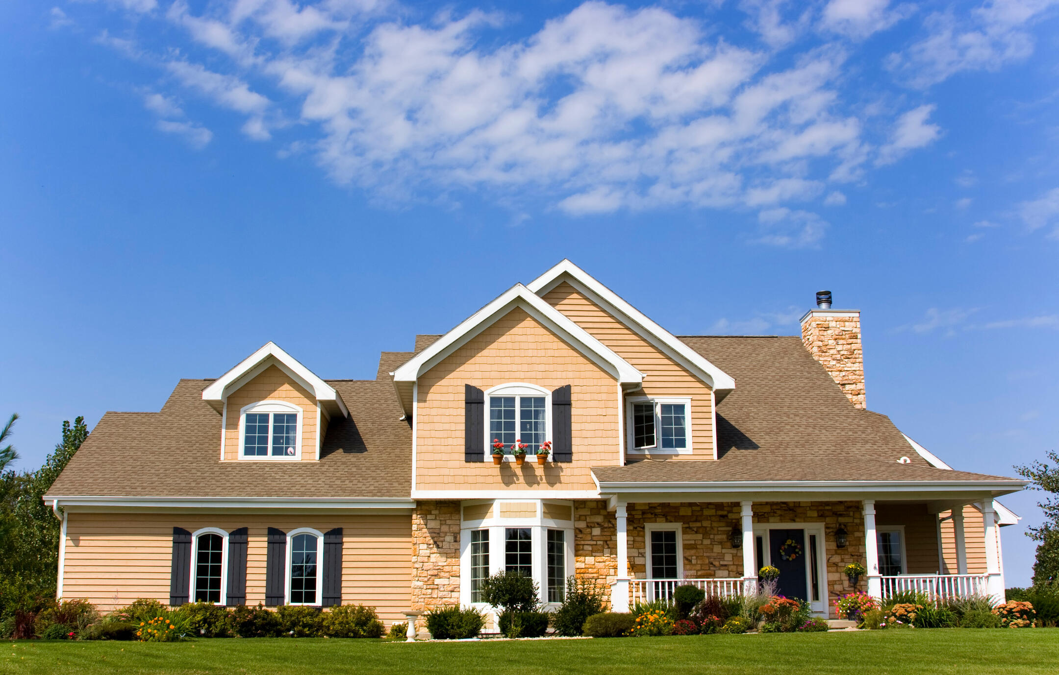 metal roof vs shingles-light tan colored house with brown shingle roof